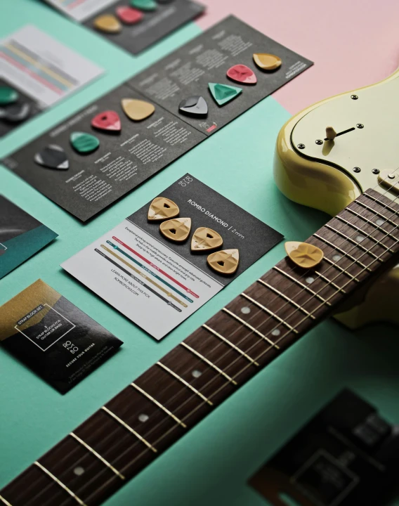 a yellow guitar sitting on top of a table, green and pink colour palette, beautiful brand labels, tactile buttons and lights, behance lemanoosh