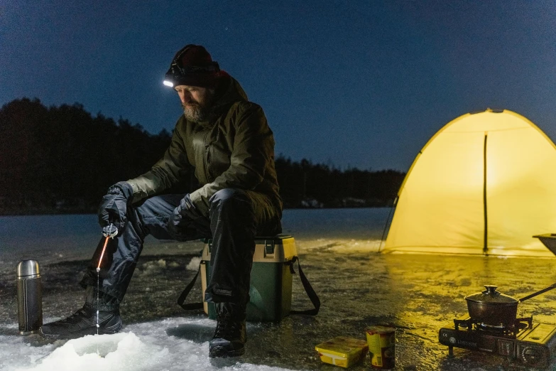 a man sitting next to a yellow tent in the snow, floating lights, fishing, leds visor helmet, vollumetric lighting