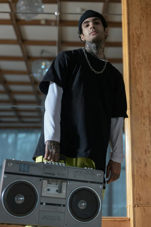 a man with a ghetto box standing in front of a set of speakers