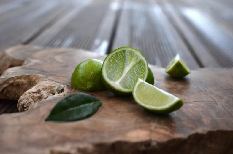 a slice of lime sitting on top of a wooden cutting board, unsplash, beautiful surroundings, aged 13, mint, 🍸🍋