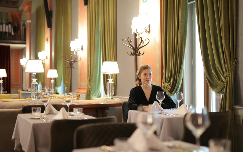 woman sitting in a dinning room filled with chairs