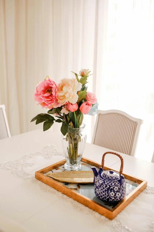 a vase of roses in a glass vase is placed on a tray