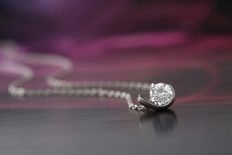 a diamond necklace sitting on top of a table, a macro photograph, inspired by Evert Collier, curved body, skewed shot, top down angle, highly capsuled