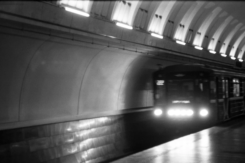 a black and white photo of a subway train pulling into a station, a black and white photo, by Maurycy Gottlieb, flickr, in moscow centre, lighting, 2000s photo, washington dc