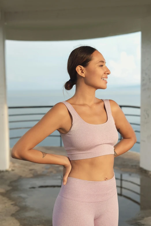 a woman wearing a pink yoga suit and smiling