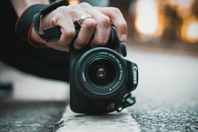 a person kneeling down and holding onto a camera