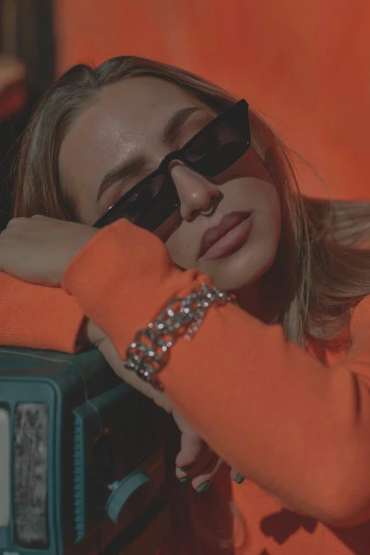 a woman wearing sunglasses leaning on a radio, inspired by Elsa Bleda, trending on pexels, orange shoulder pads, jewelry, neon aesthetic, group photo