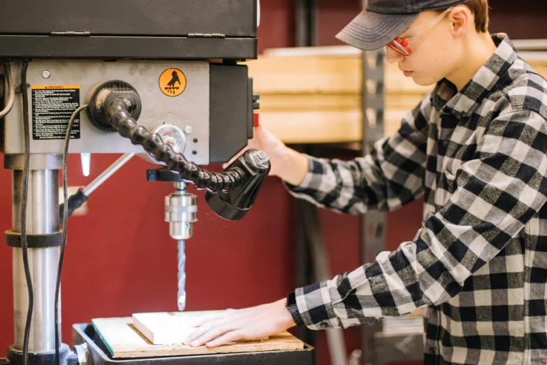 a man working on a machine in a workshop, pexels, avatar image, student, non-binary, 1 1 1 1