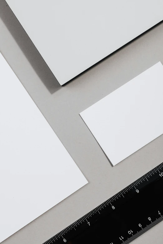 a close up of a piece of paper next to a ruler, sleek streamlined design, different sizes, zinc white, ultra resolution