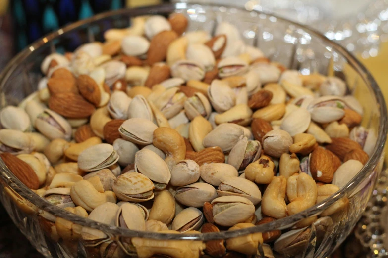 a glass bowl filled with nuts on top of a table