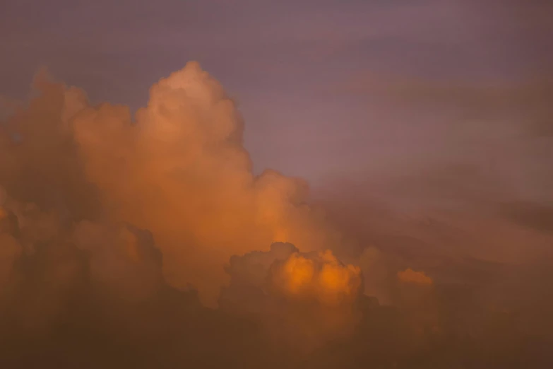 a plane flying in the sky during the golden light