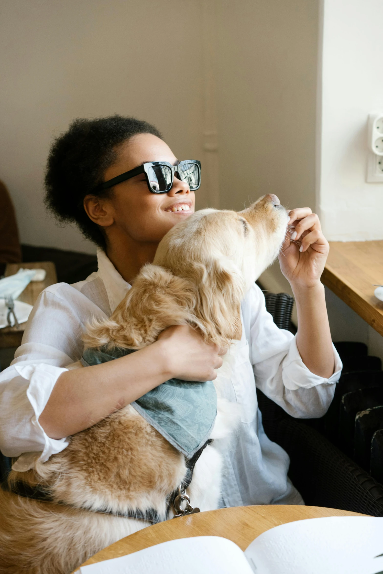 a woman sitting at a table with a dog, trending on unsplash, implanted sunglasses, hugging, small in size, ap art