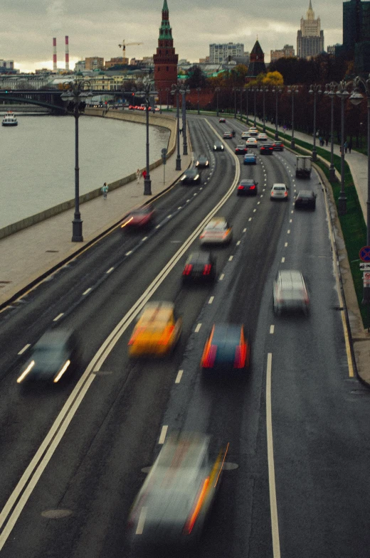 a highway filled with lots of traffic next to a river, by Adam Marczyński, unsplash, photorealism, 1980s photograph, racing, budapest, thumbnail