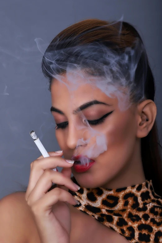 a woman is smokeing an electronic cigarette
