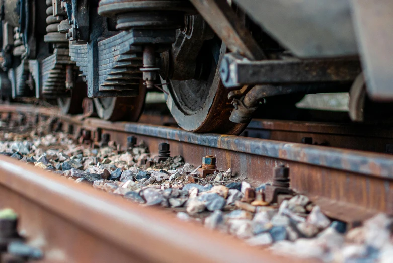 a close up of a train on a train track, rocks and metal, profile image, grey, thumbnail