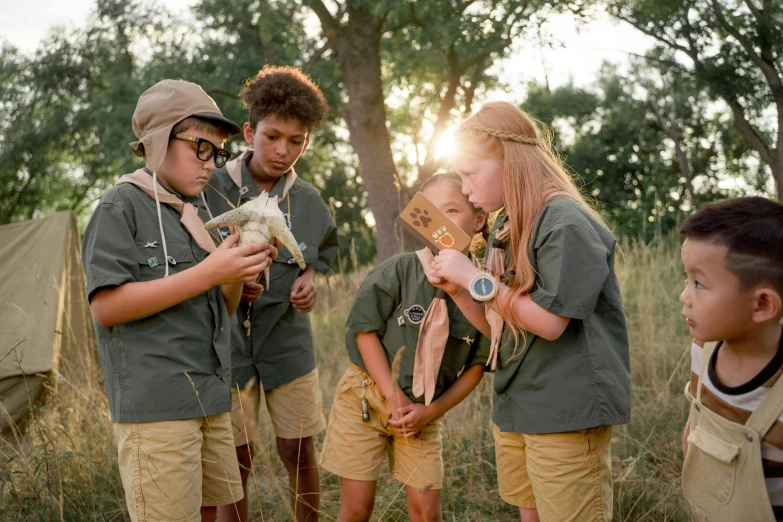 a group of young children standing next to each other, by Emma Andijewska, unsplash, renaissance, boy scout troop, safari, looking for clues, promotional image