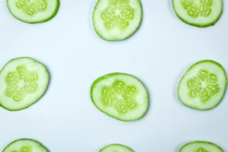 a close up of sliced cucumbers on a white surface, by Carey Morris, trending on pexels, circle face, patterned, 🍸🍋, on clear background