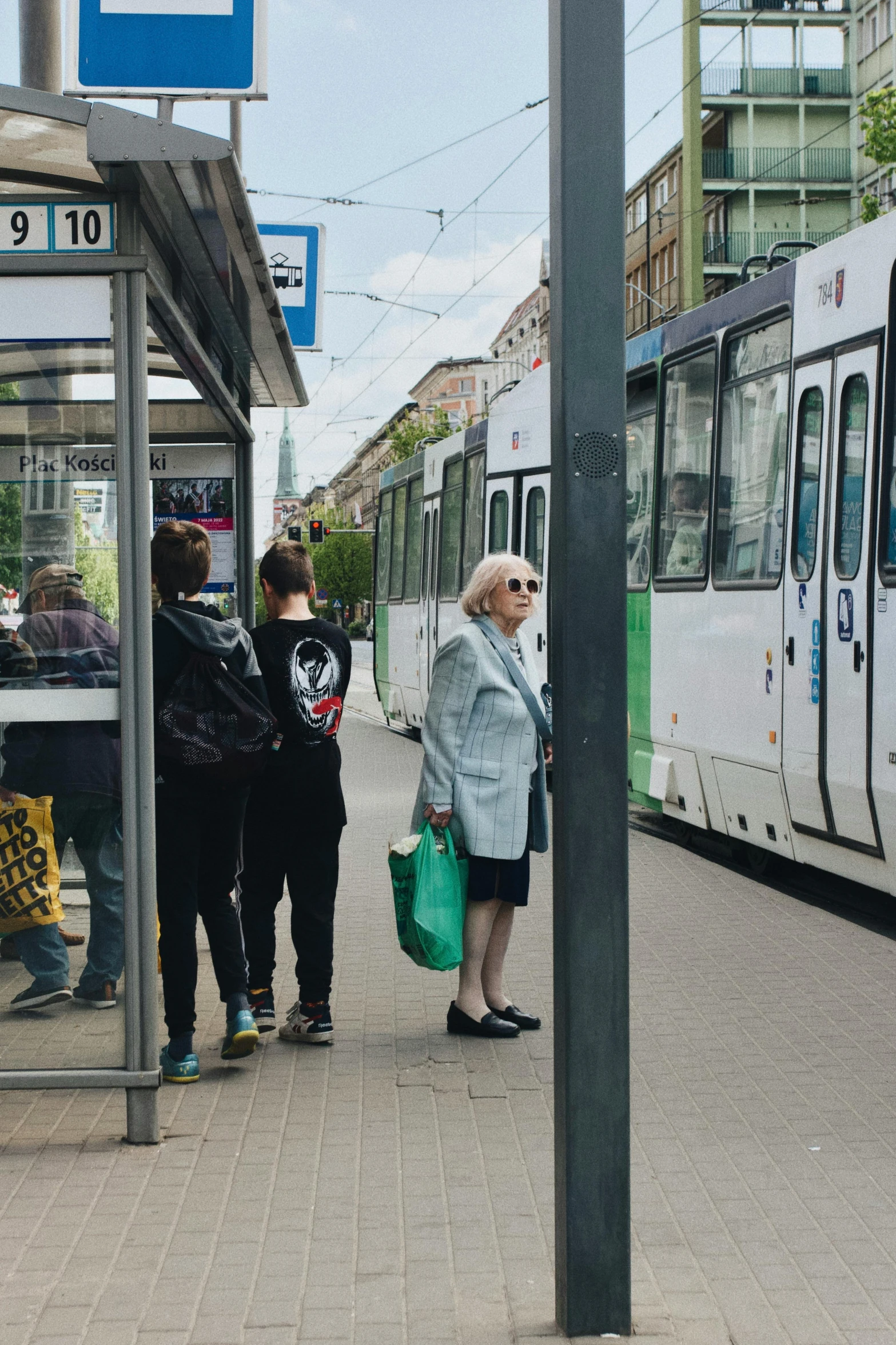 some people are waiting for the train at a stop