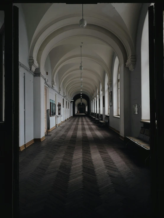 an empty hall with long columns and pictures on the walls