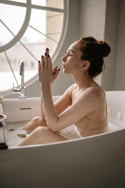 a woman sitting in a bath tub next to a window, trending on pexels, soft flawless pale skin, smoking body, partially cupping her hands, better known as amouranth