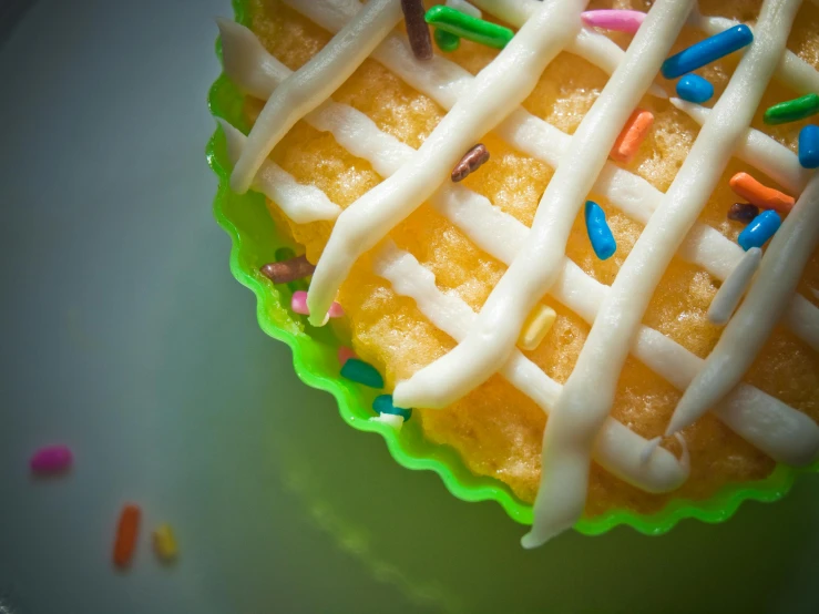 a cupcake with frosting and sprinkles on a plate, pexels, photorealism, lattice, yellow and green, square, post-processed