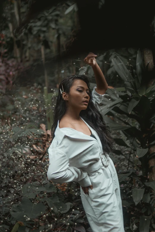 a woman standing in the middle of a forest, an album cover, pexels contest winner, sumatraism, wearing a white button up shirt, action glamour pose, cindy avelino, dark backdrop