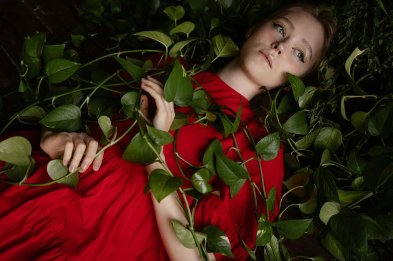 a woman in a red dress surrounded by plants, inspired by Konstantin Somov, unsplash, magic realism, hugh kretschmer, dakota fanning, portrait image, with ivy
