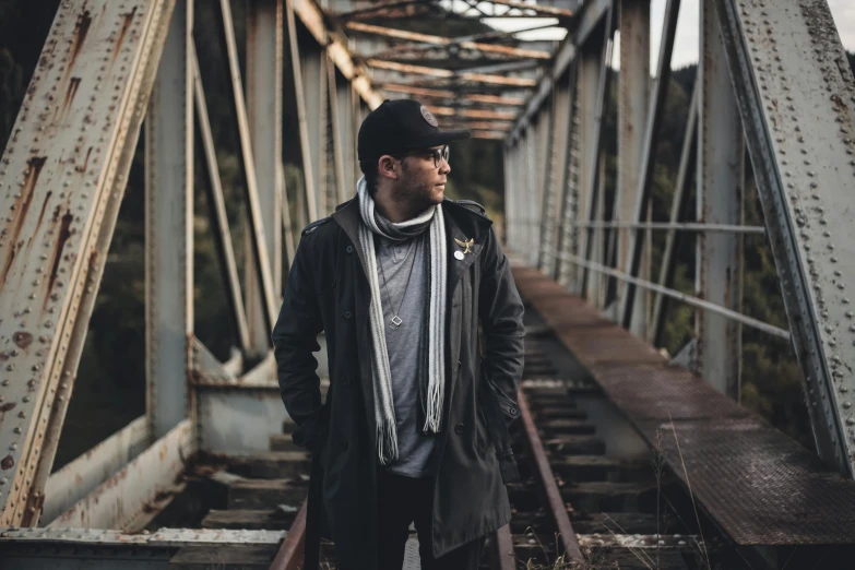 a man standing on top of a train track, a portrait, inspired by Michael Ray Charles, unsplash, lyco art, wearing urban techwear, on a bridge, promotional image, profile picture