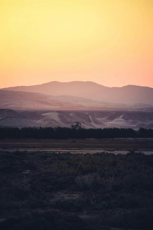 the sun is setting over the mountains in the distance, by Jacob Toorenvliet, sand and desert environment, shot from a distance, moroccan, hollister ranch