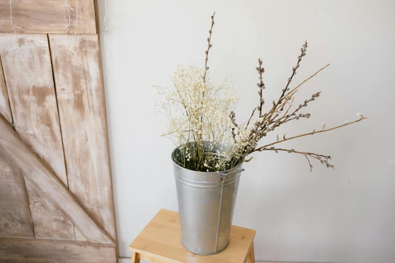 a flower pot sitting on top of a wooden table, inspired by Maruyama Ōkyo, unsplash, process art, silver，ivory, trash can, willow plant, large tall