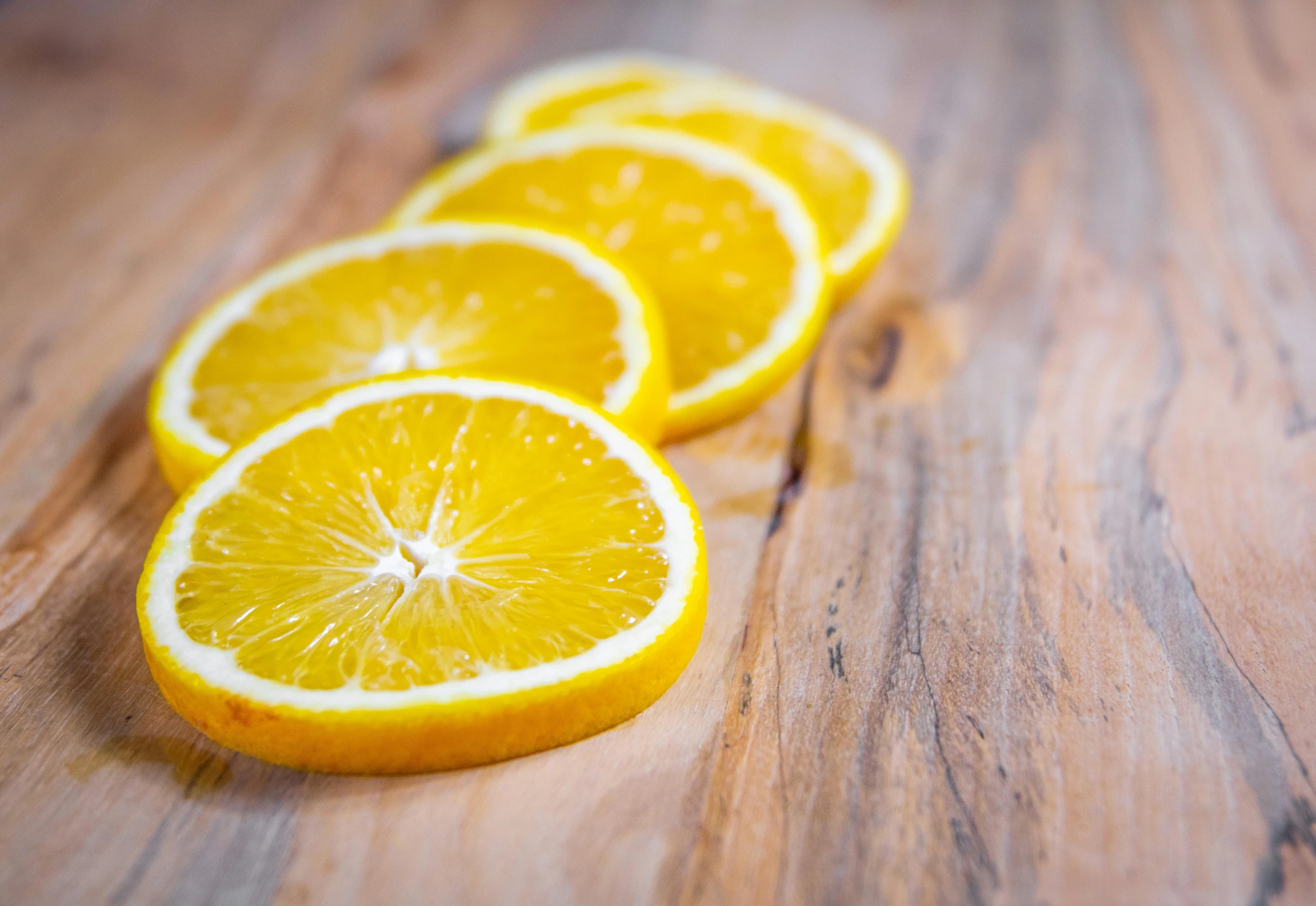 a group of orange slices sitting on top of a wooden table, profile pic, multiple stories, yellow aureole, set photo