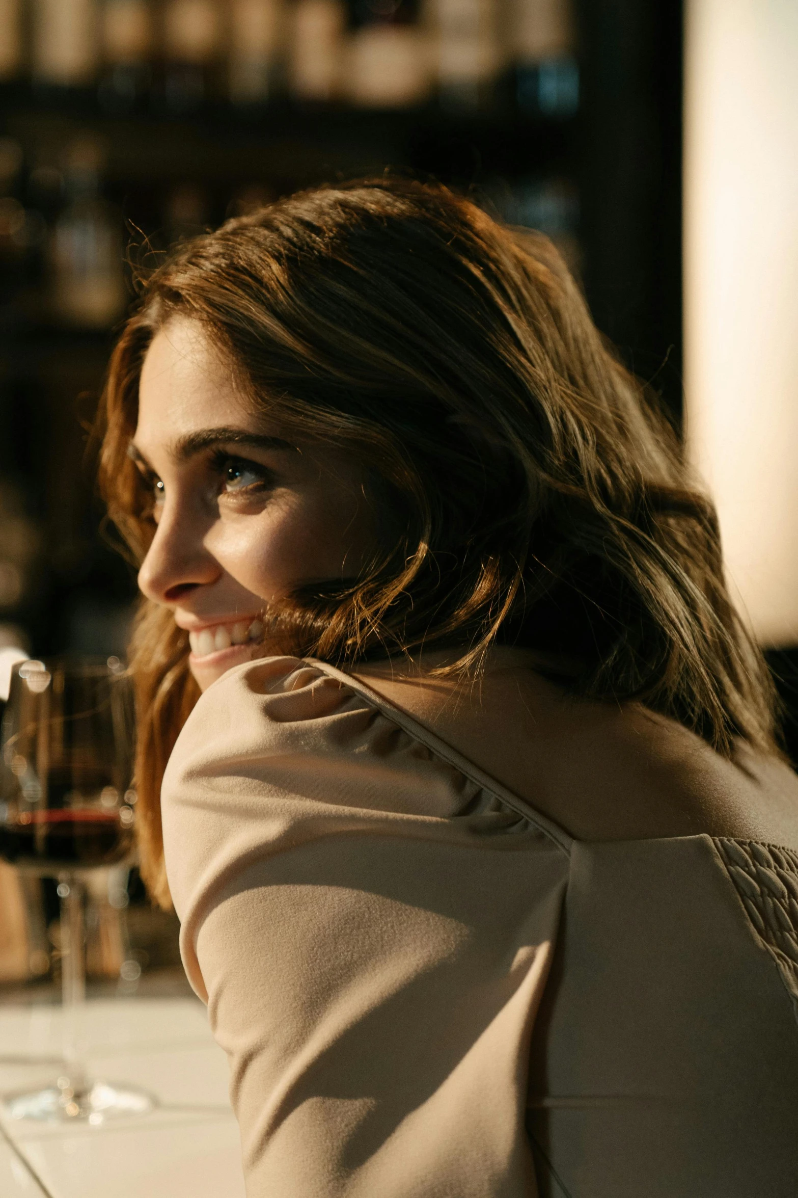 a woman sitting at a table with a glass of wine, alison brie, medium head to shoulder shot, shot with sony alpha 1 camera, sitting at the bar