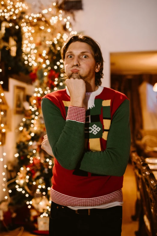 man looking sideways in front of lit tree