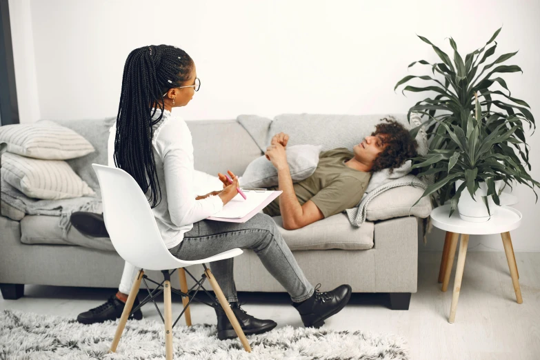 a man and woman sitting on a couch in a living room, psychology, sydney park, profile image, in small room