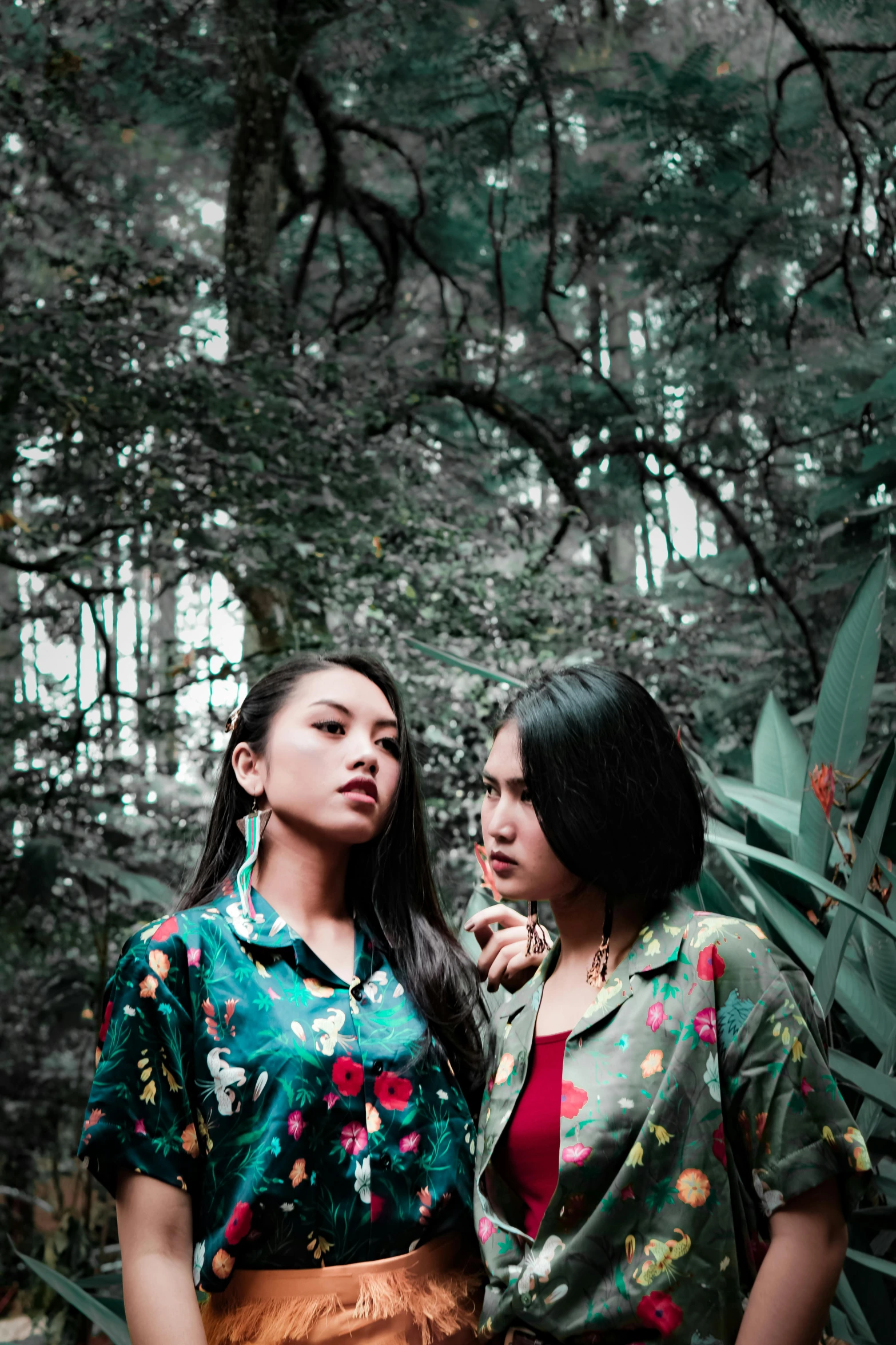 two women standing next to each other in a forest, an album cover, by Basuki Abdullah, sumatraism, promo shoot, profile image, floral, concert