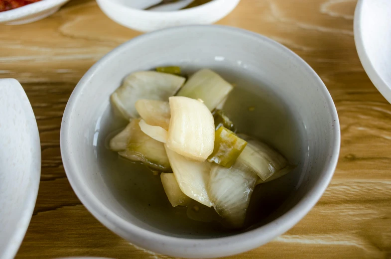 a close up of a bowl of food on a table, extra pickles and onions, longque chen, square, minimalist