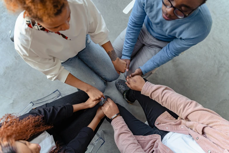 a group of people standing around each other, by Nina Hamnett, trending on pexels, renaissance, laying down with wrists together, healthcare, high-angle, ethnic group