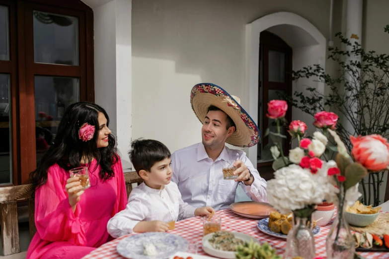 a couple of people that are sitting at a table, wearing sombrero, husband wife and son, celebration, jeszika le vye