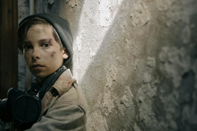 a person leaning against a wall with a camera, war boys, skin wounds, cinematic colour grading, kids