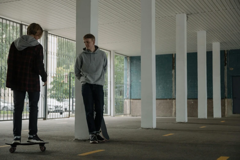 a couple of young men standing next to each other on skateboards, by Jacob Toorenvliet, opening scene, calmly conversing 8k, on the concrete ground, felix kelly