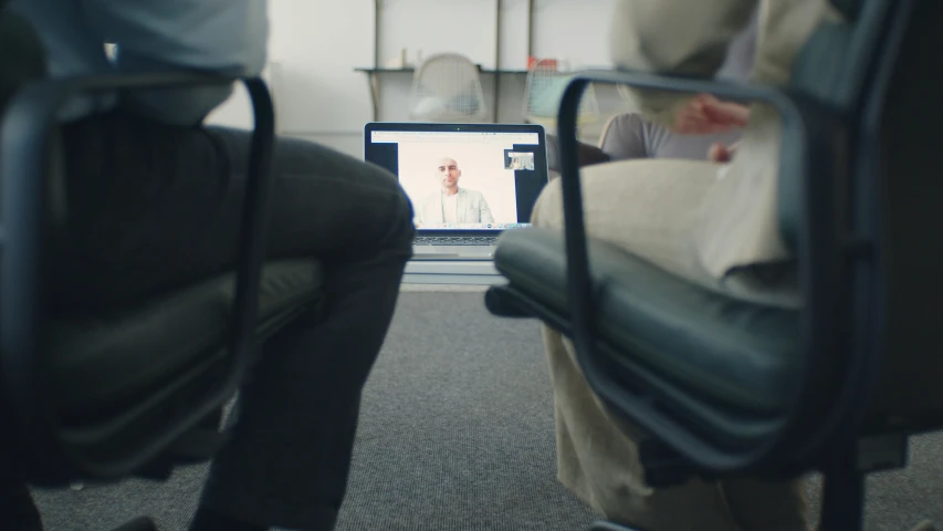 two people sitting in front of a laptop computer, by Jacob Toorenvliet, unsplash, video art, in a meeting room, ignant, from the distance, 3 heads