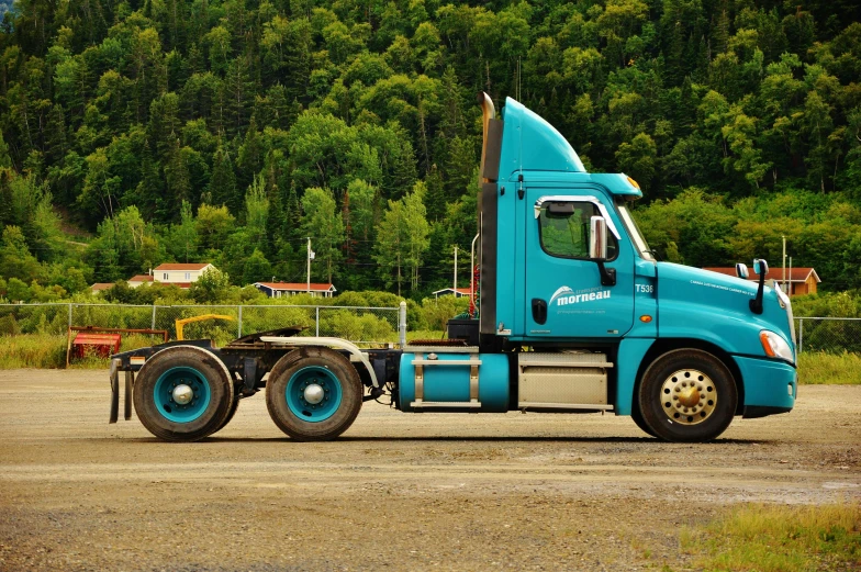 a blue semi truck parked in a parking lot, a portrait, by Jim Nelson, unsplash, square, forestry, turqouise, side view profile