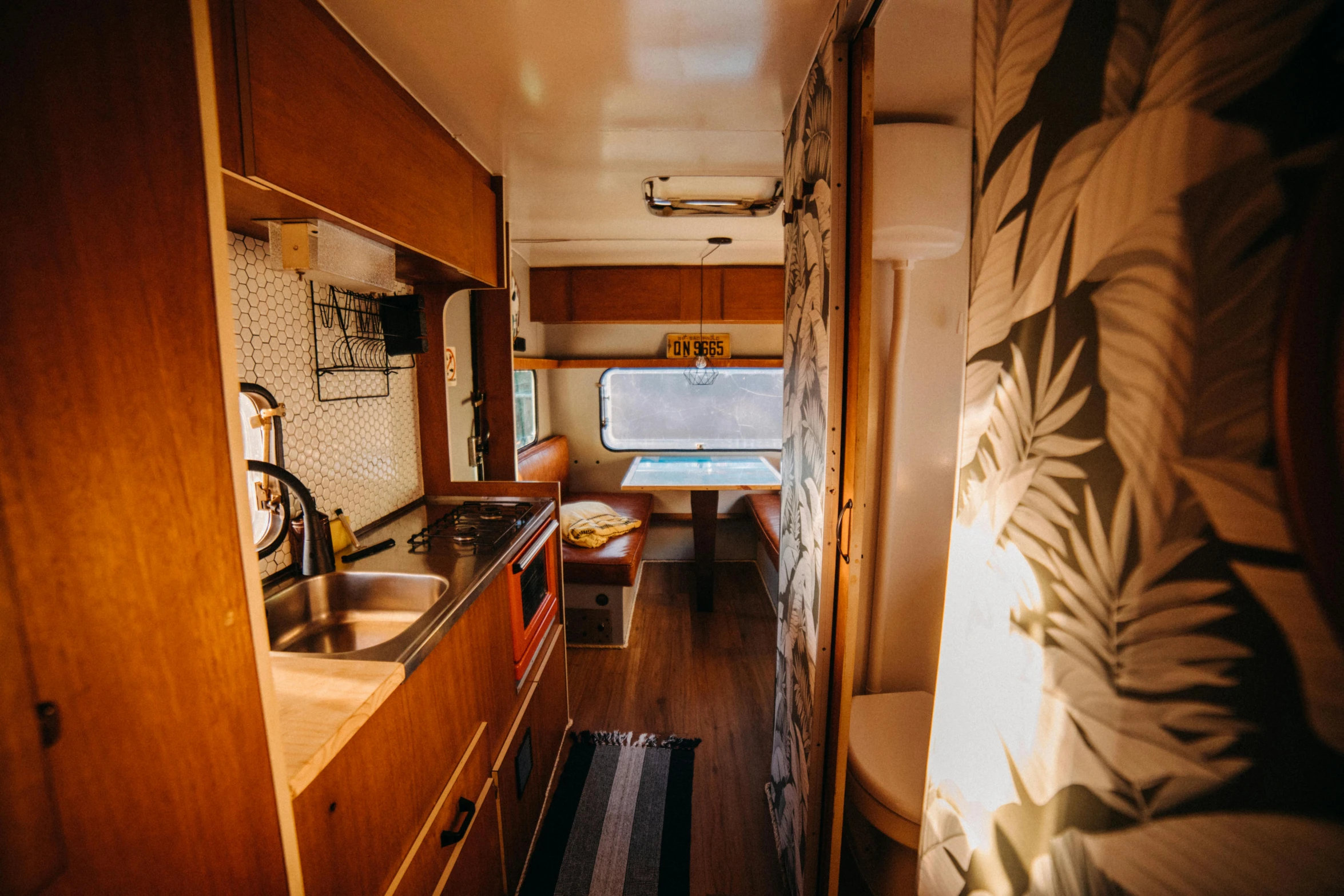 a narrow hallway connects to a modern looking kitchen and living room