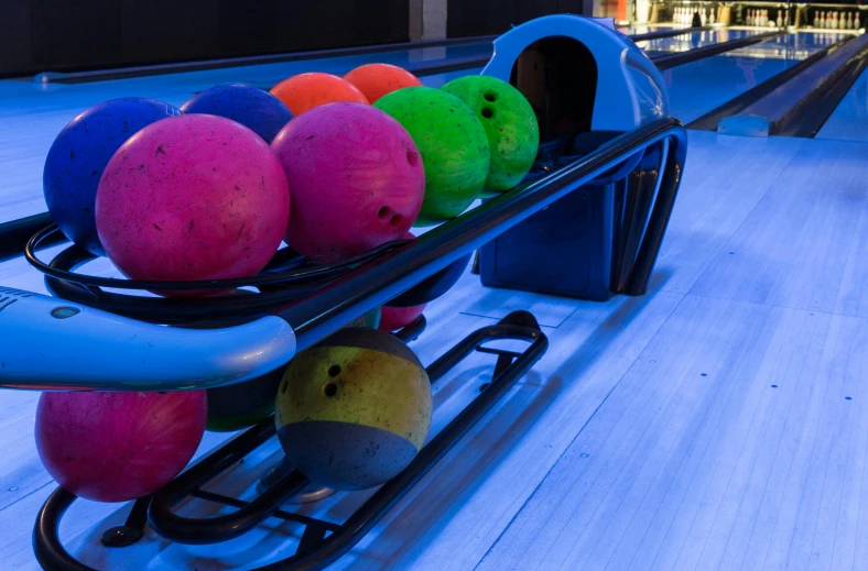 a row of bowling balls in a bowling alley, unsplash, purple and blue neons, bowl filled with food, thumbnail, rainbow tubing