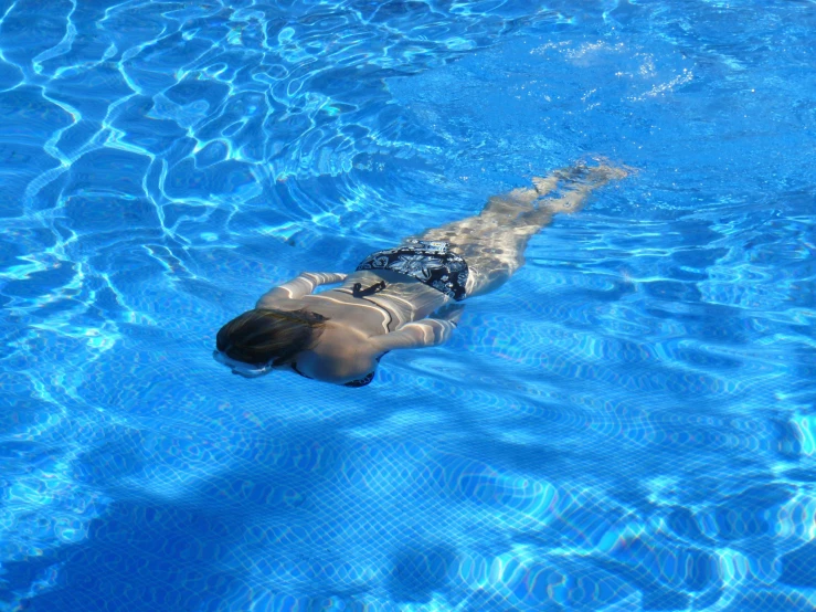 a person swimming in a pool on a sunny day, marbella, profile image