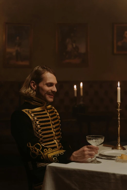 a man sitting at a table with a glass in front of him