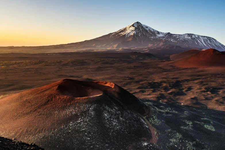 a mountain with snow on it is seen at dusk