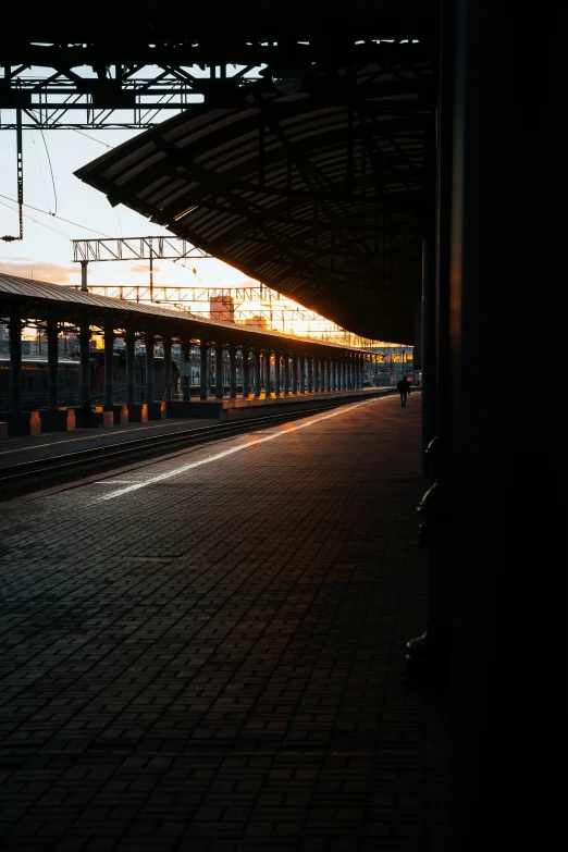 a view of a train station at sunset from across the track