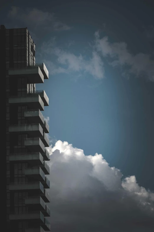 a airplane is flying near two building's under cloudy skies