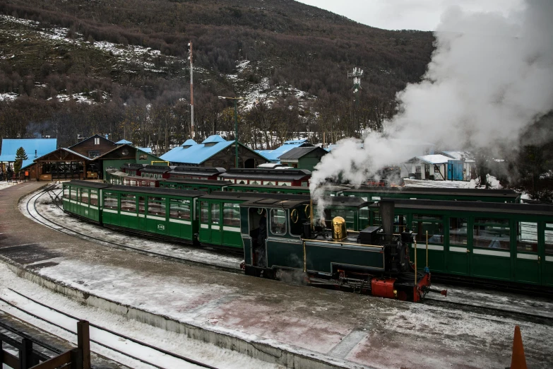 a green train traveling down train tracks next to a mountain, frostine engine, square, russian, thumbnail